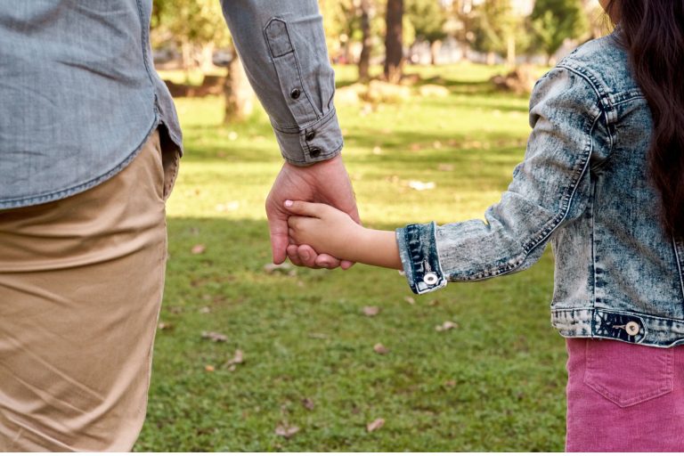 Parent and child holding hands.