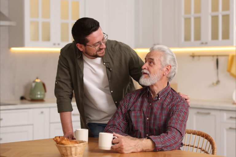 A father and son talking in a kitchen.