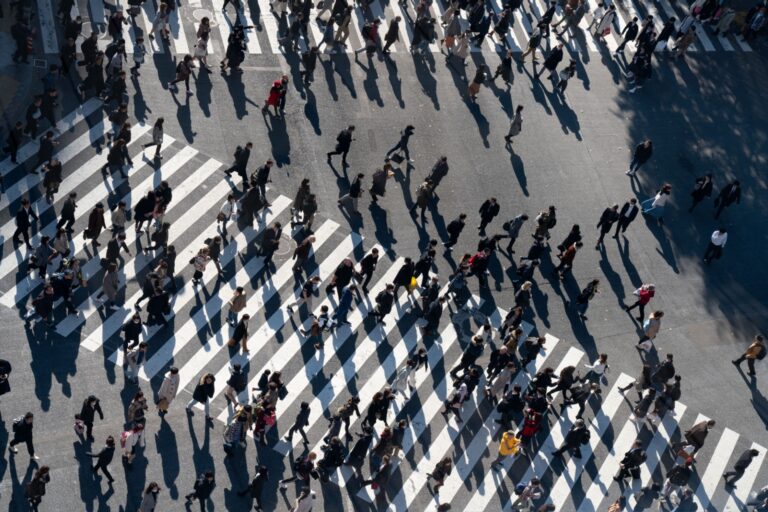 A crowd of people crossing a road.